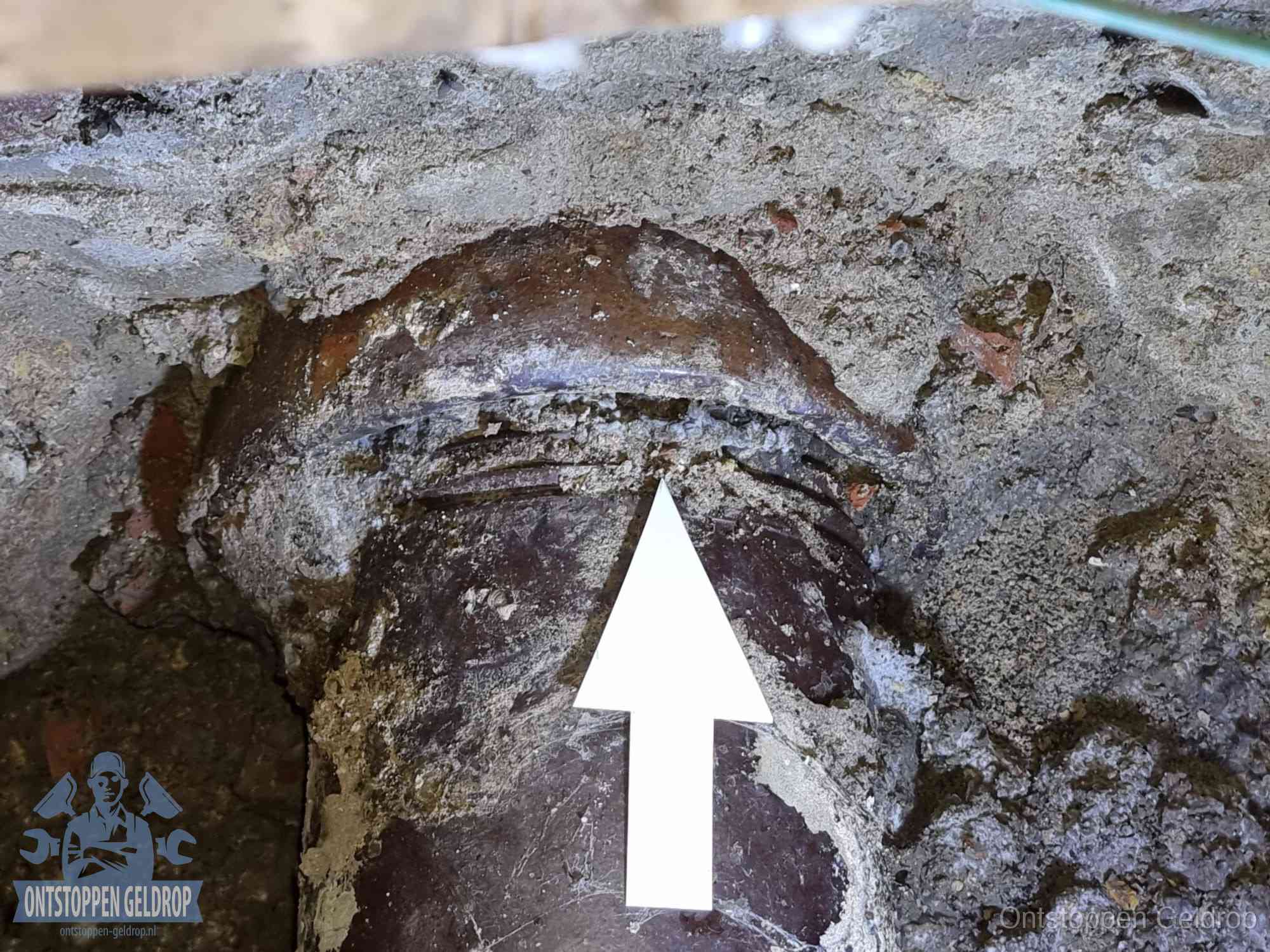 Blootgelegde oude rioolaansluiting met een scheur als oorzaak van een rioolverstopping in Geldrop