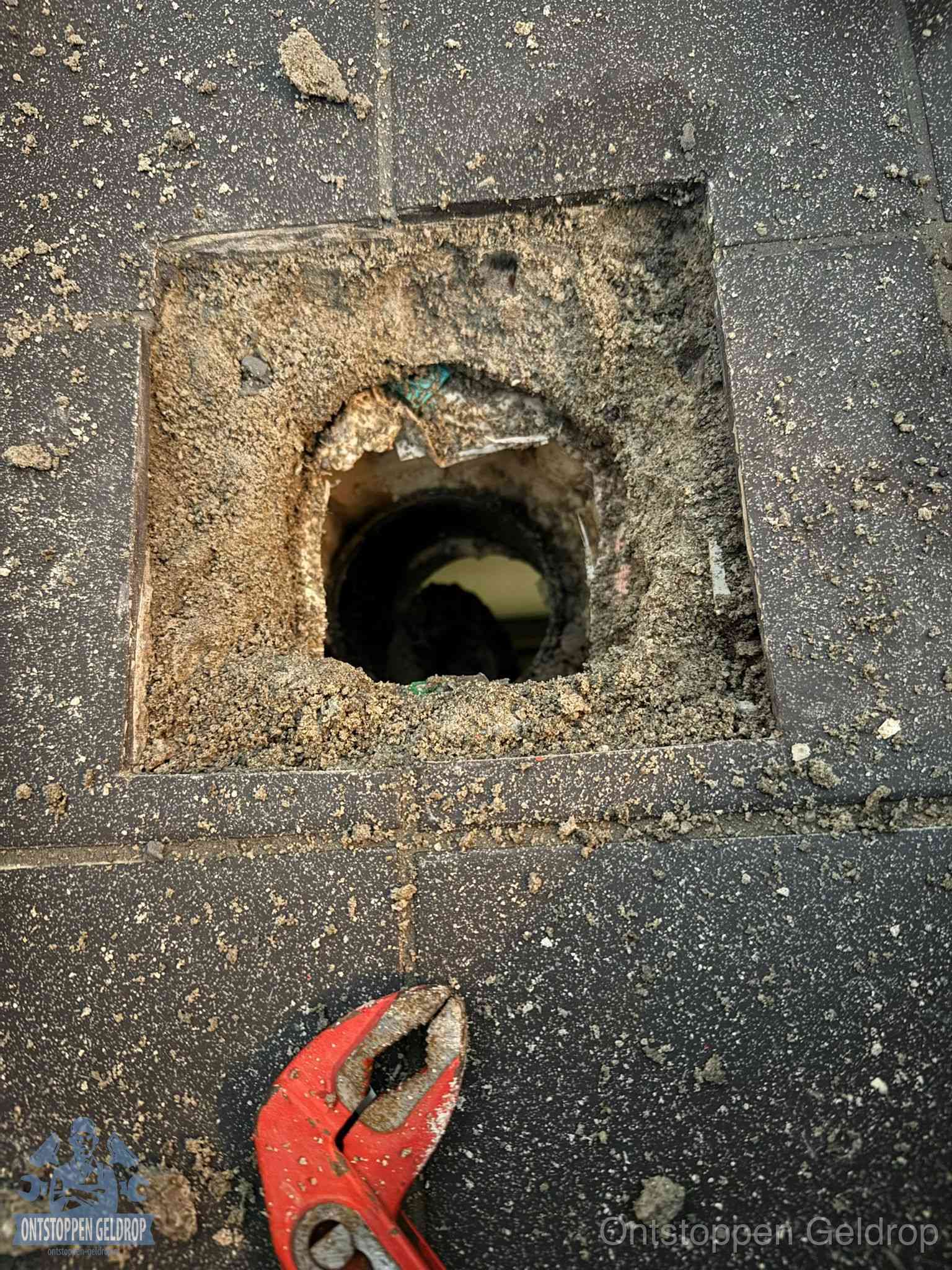 Geopend rioolputje op de erfgrens dat laat zien wie eigenaar is van de riolering in Geldrop