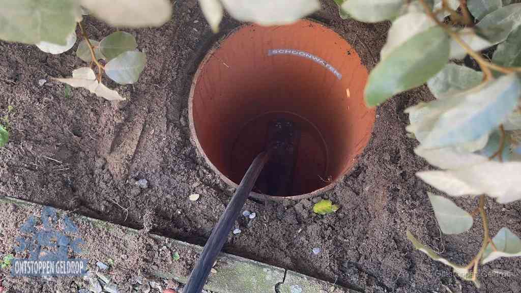 Open inspectieput in de tuin waar een veer rioolvliegjes en stankoverlast aanpakt in Geldrop