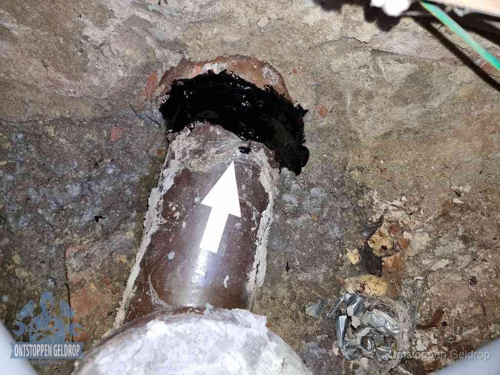 Een oude gres rioolbuis met een beschadigde koppeling onder de vloer, oorzaak van terugkerende structurele wc-problemen in Geldrop Een oude gres rioolbuis met een beschadigde koppeling onder de vloer, oorzaak van terugkerende structurele wc-problemen in Geldrop