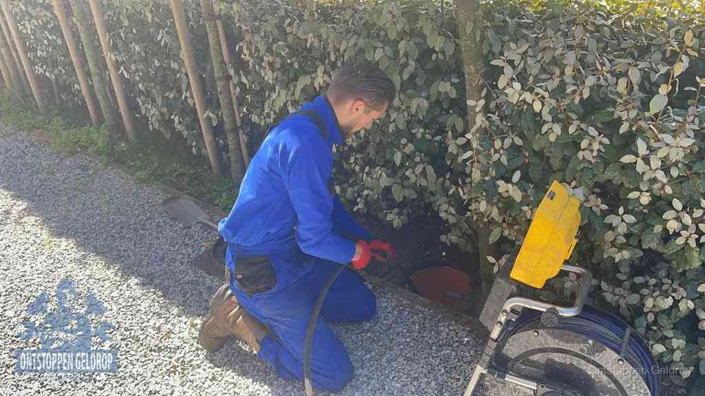 Monteur aan het werk bij een rioolput, de werkwijze voor riool ontstoppen in Geldrop