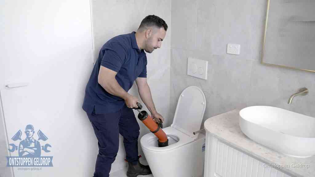 Een monteur gebruikt een handmatige perspomp (toiletontstopper) op een wandcloset tijdens het professioneel wc ontstoppen in Geldrop Een monteur gebruikt een handmatige perspomp (toiletontstopper) op een wandcloset tijdens het professioneel wc ontstoppen in Geldrop