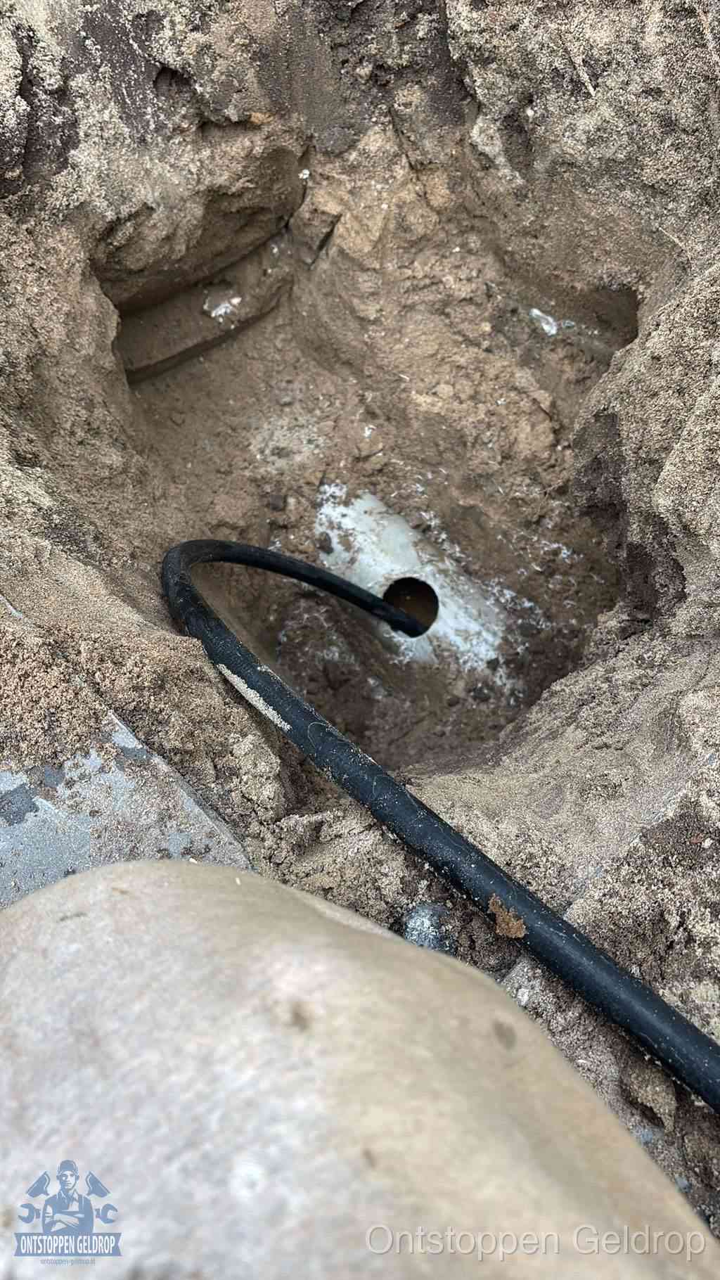 Uitgegraven rioolbuis in de grond, hulp om zelf het riool te ontstoppen in Geldrop